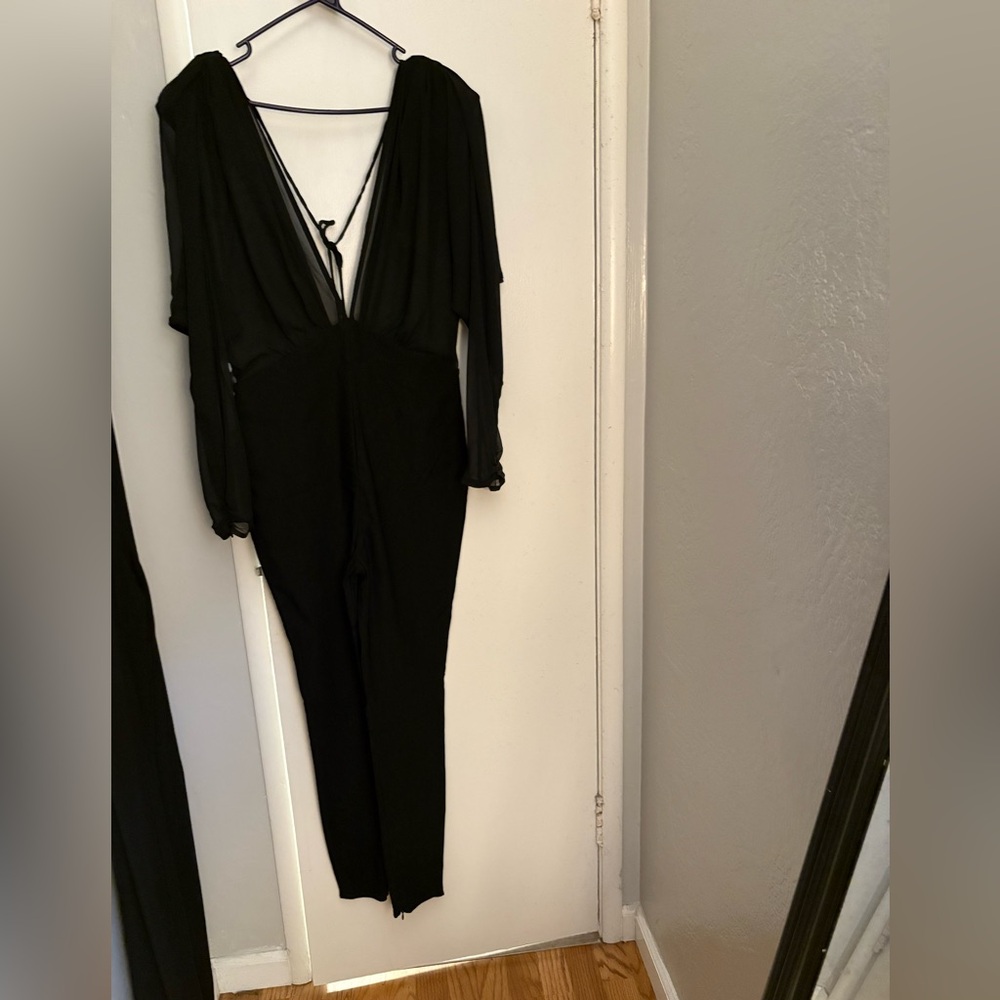 NWT Black sheer top plunging neck and back long sleeve jumpsuit.
